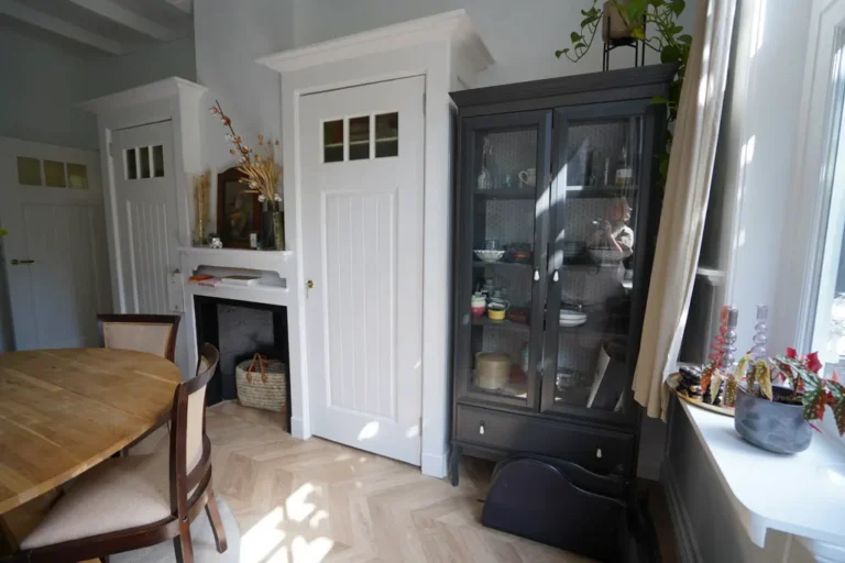 Dining room with a dark display cabinet and a classic fireplace