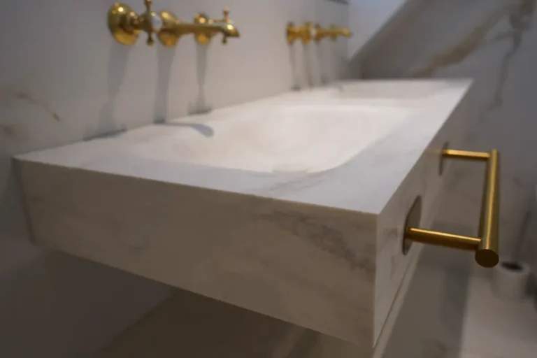 Solid marble washbasin with gold wall-mounted taps
