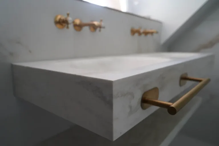 Marble sink with gold taps and a towel rail