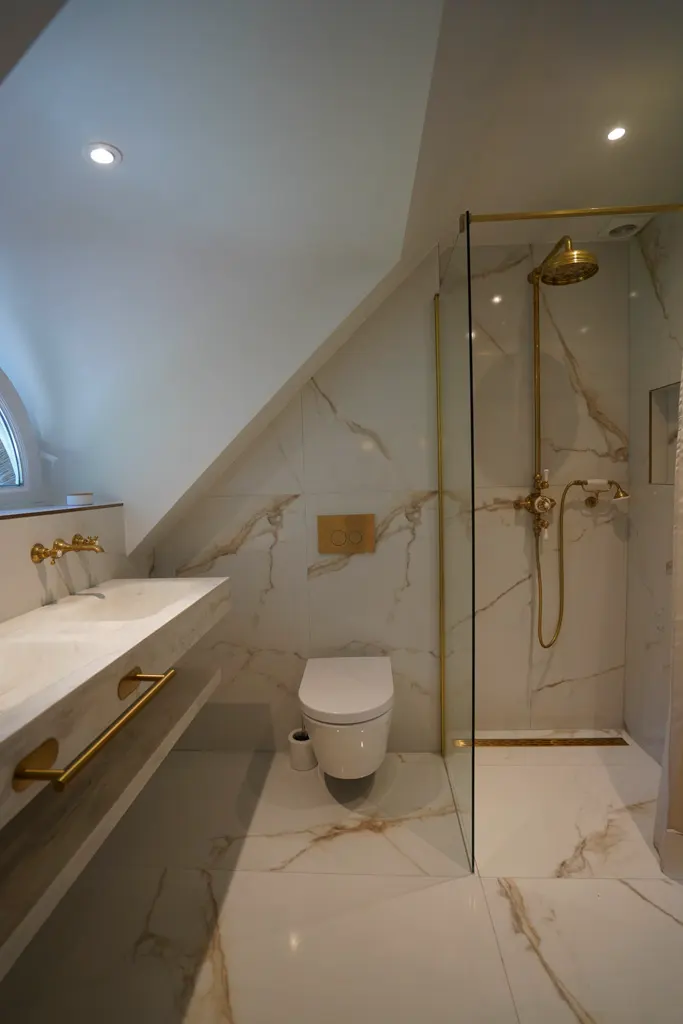 Attic bathroom in marble with a walk-in shower and gold accents