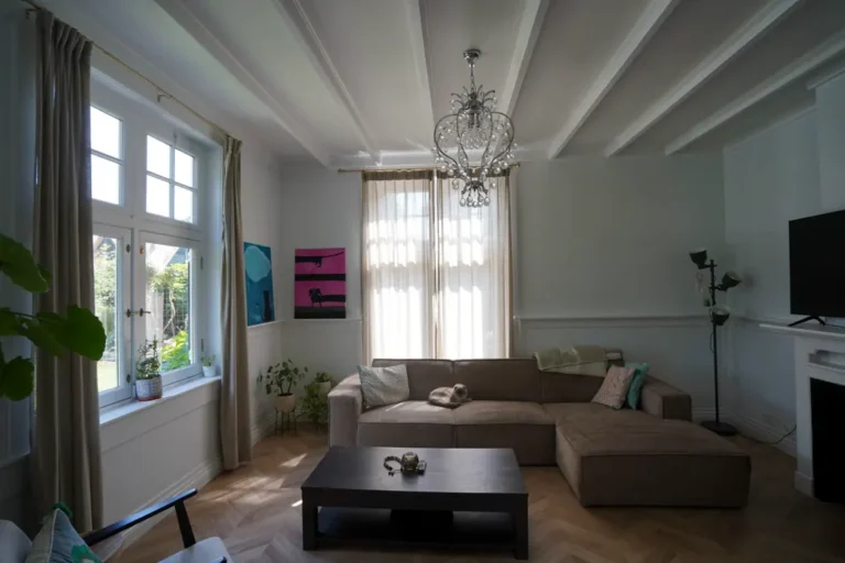 Bright living room with a corner sofa and beamed ceiling