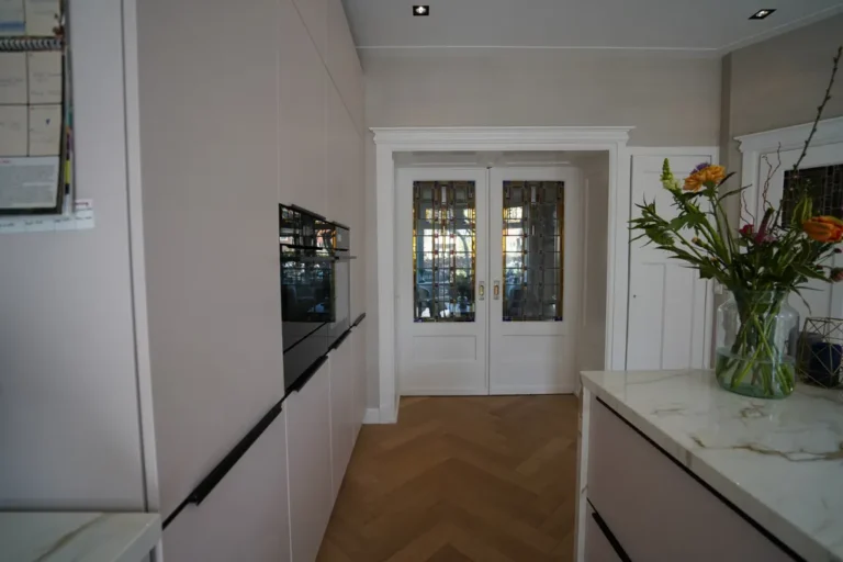 Kitchen with built-in ovens, tall handleless units and stone worktop – Meindert Hobbemastraat, Heemstede