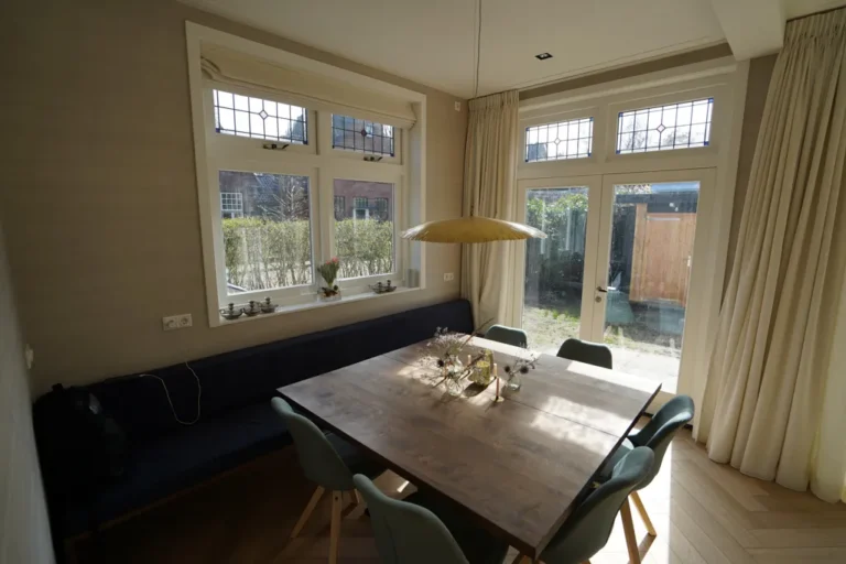 Dining area with built-in bench under leaded windows and garden doors – Meindert Hobbemastraat, Heemstede