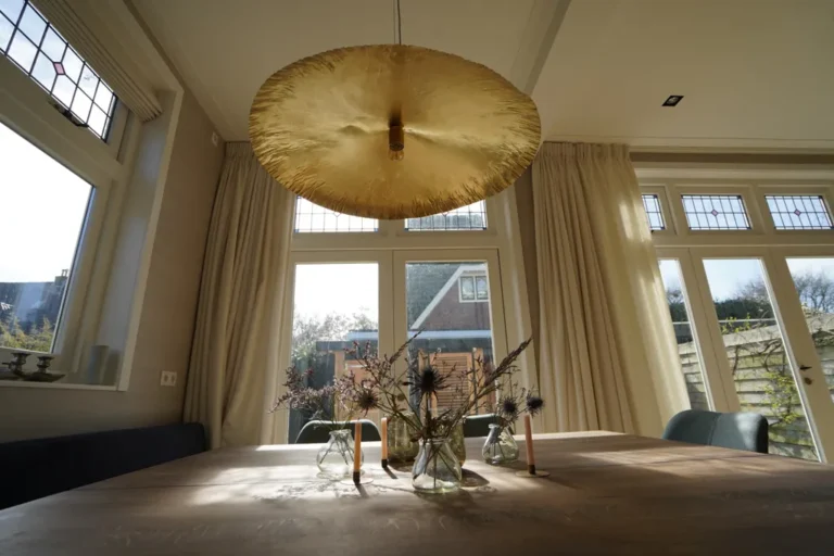 Dining table under a brass pendant beside tall garden doors – Meindert Hobbemastraat, Heemstede