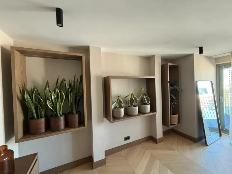 Built-in display niches with plants on a herringbone floor