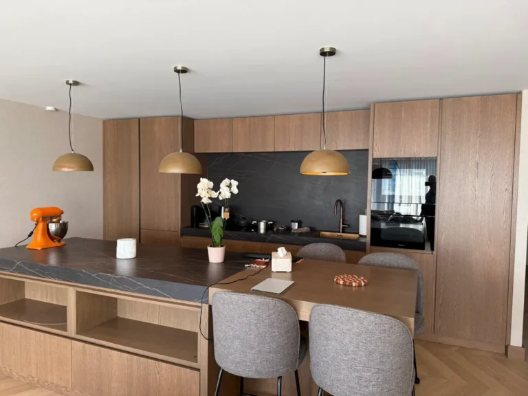 Contemporary kitchen and dining area with wood cabinetry and pendant lights