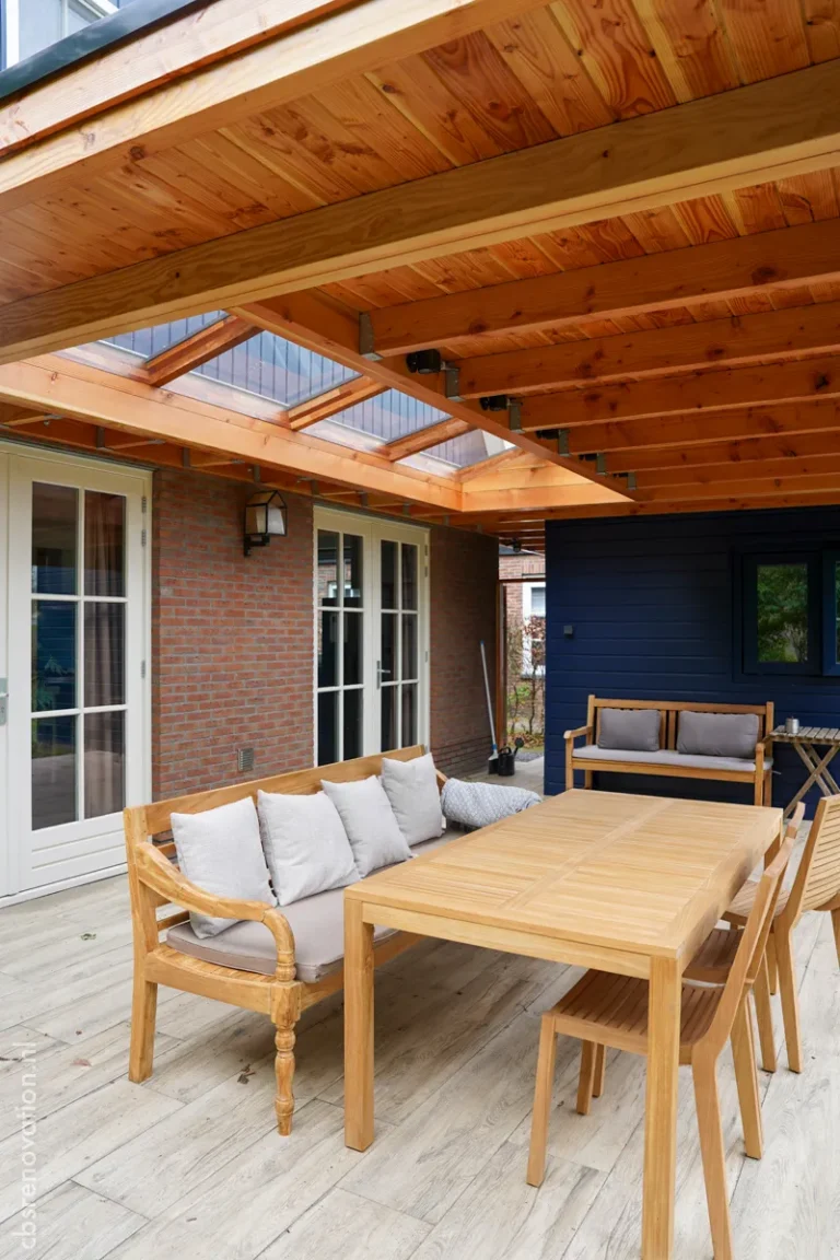 Covered terrace with a teak lounge sofa and dining table