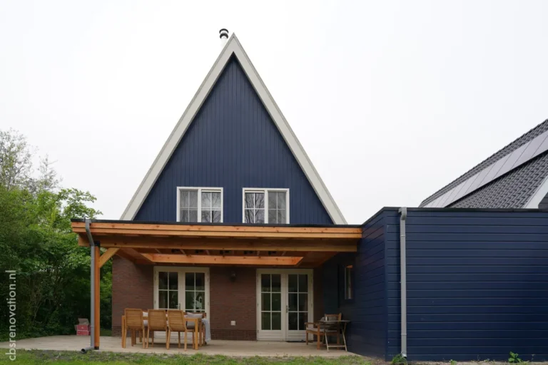 Rear facade of the renovated house with a covered veranda and solar panels