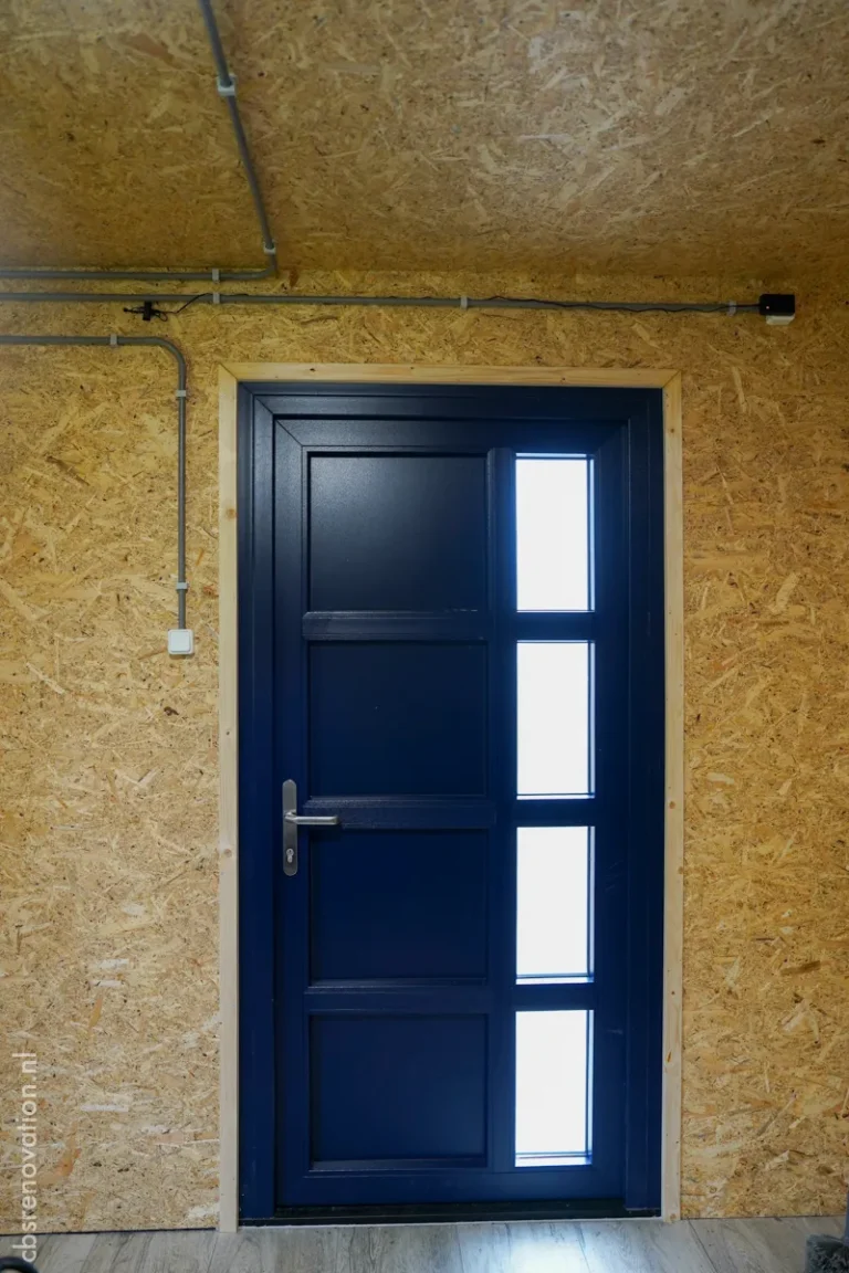 Navy blue entrance door seen from inside the garden room