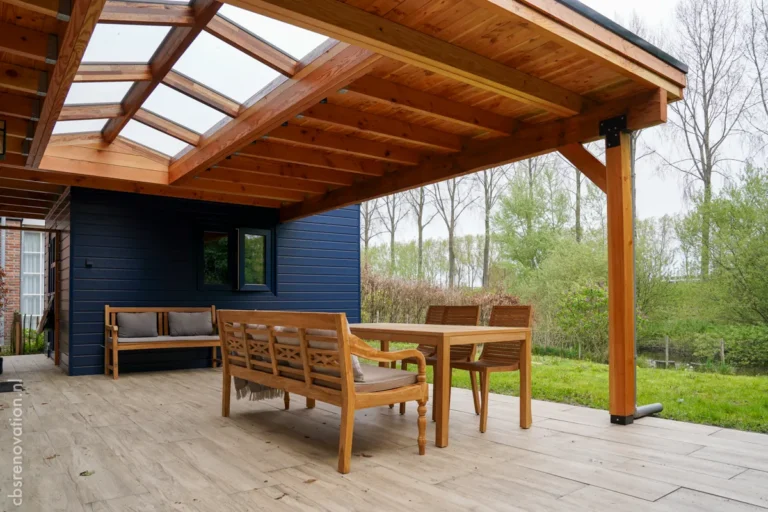 Covered wooden terrace with seating next to the dark-blue garden room