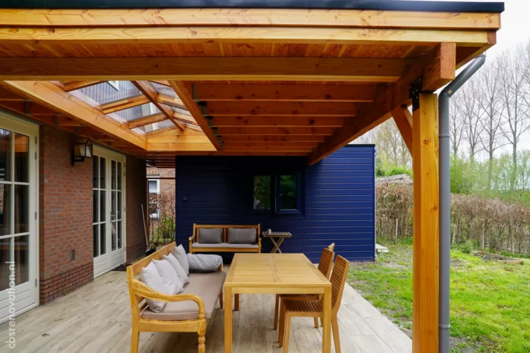 Covered veranda with lounge and dining furniture by the house's French doors