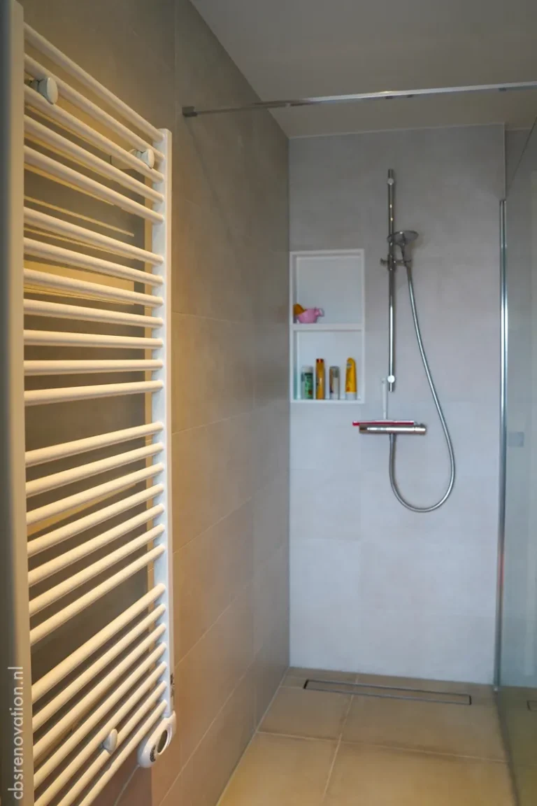 Walk-in shower with beige microcement walls and a towel radiator