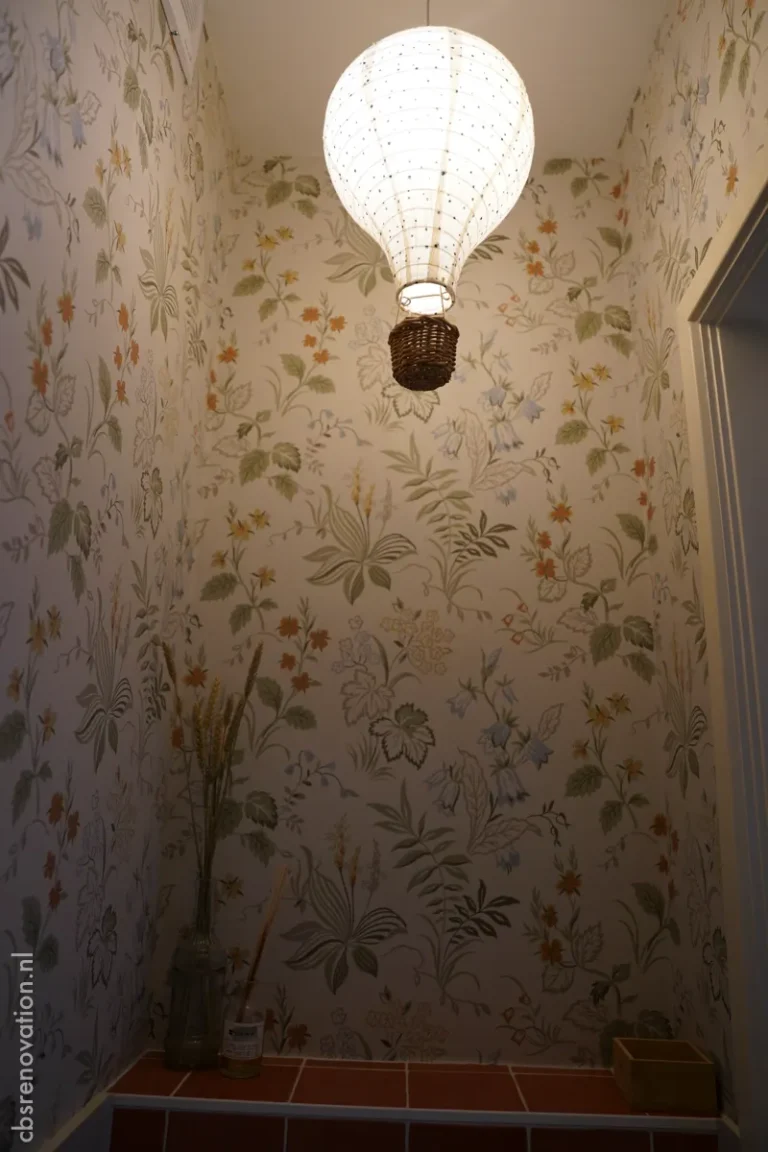 Toilet with botanical wallpaper and a woven pendant lamp