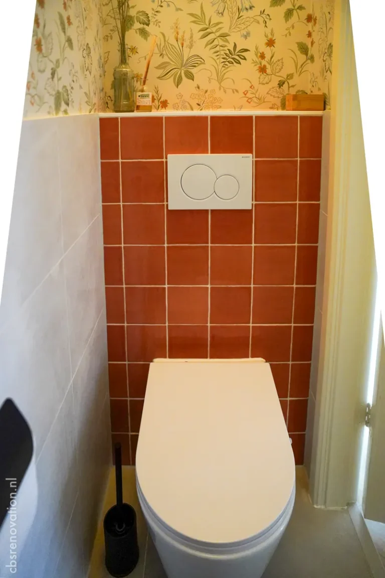 Wall-hung toilet with terracotta tiles and floral wallpaper