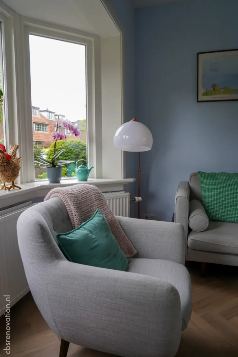 Grey armchair by the bay window in a blue living room