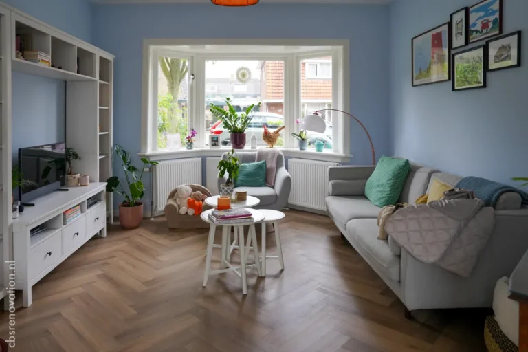 Renovated living room with a corner sofa, bay window and herringbone floor