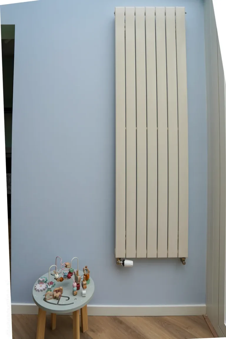 Vertical designer radiator on a blue wall