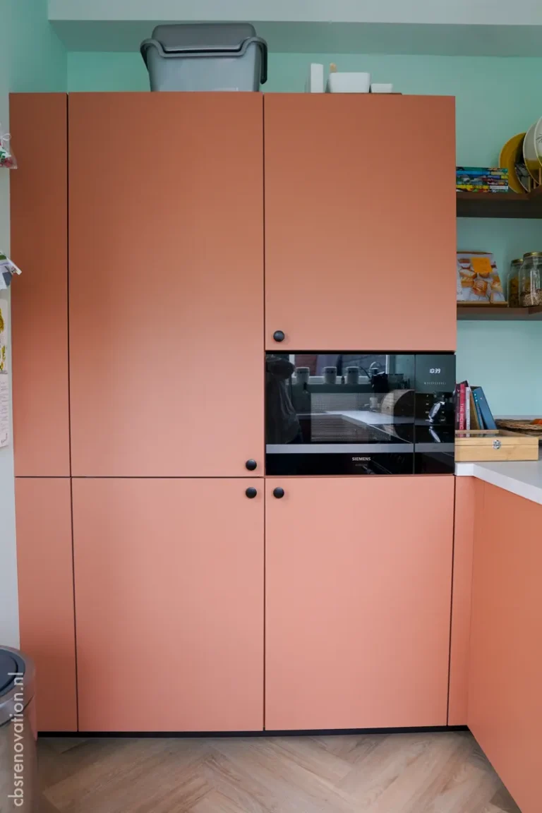 Kitchen with terracotta-coloured cabinets and a built-in oven