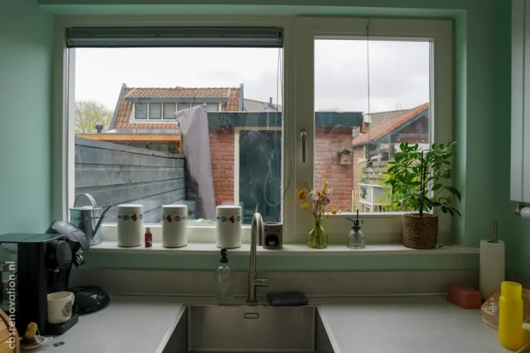 Kitchen sink beneath the window with a rooftop view