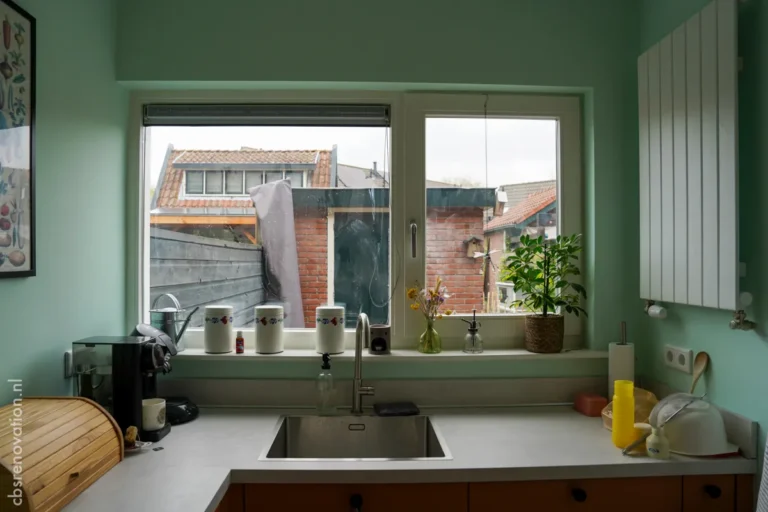 Green kitchen with a sink and worktop under the window