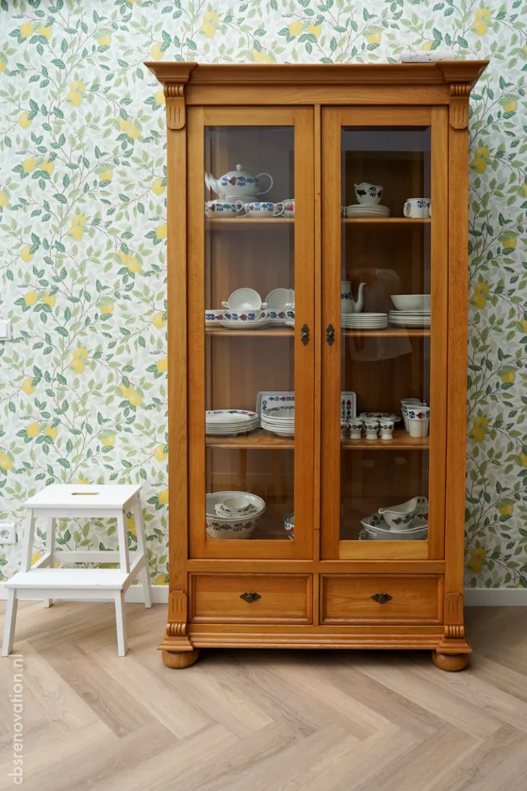 Antique display cabinet filled with china in a renovated room