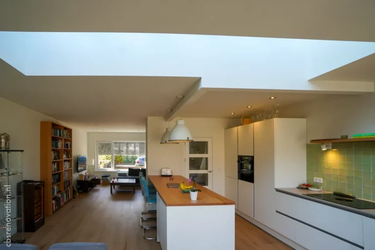 Bright modern kitchen with an island counter, open layout leading to a cozy living area, showcasing a recent renovation.