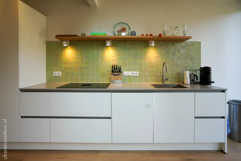 Modern kitchen with sleek cabinetry, green tiled backsplash, under-cabinet lighting, and integrated appliances.