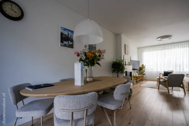 Dining room with an oval table opening onto the living room