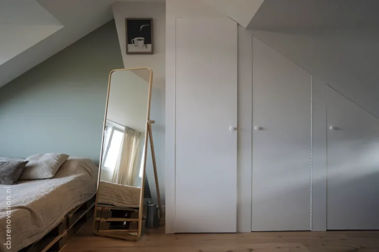 Attic bedroom with fitted wardrobes and a standing mirror