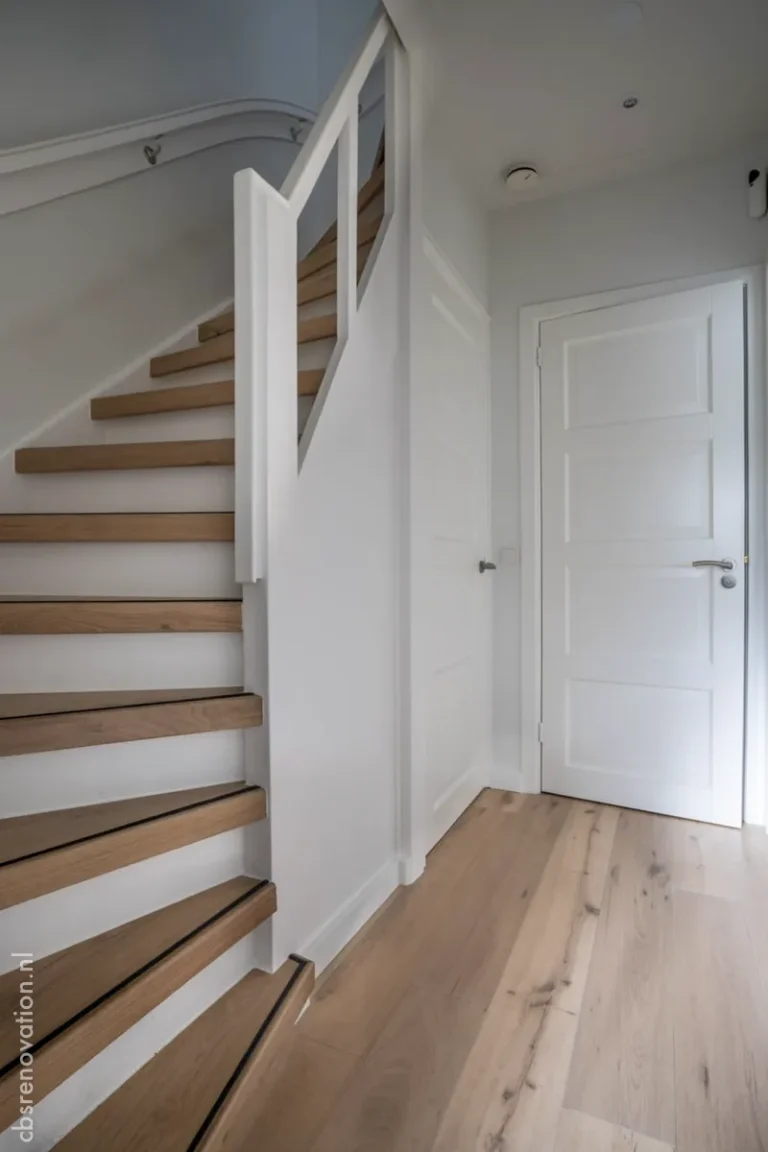 Wooden staircase with white risers in the hallway