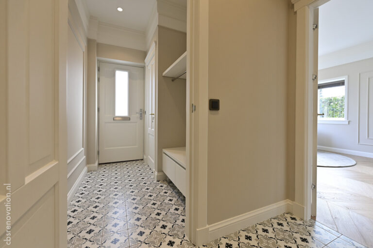 Entrance hall with patterned floor tiles and a built-in bench