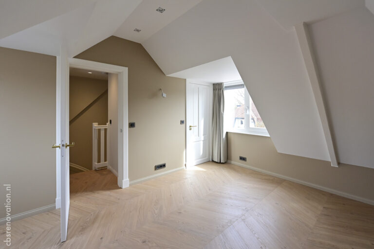 Top-floor room under the sloped roof with a herringbone floor