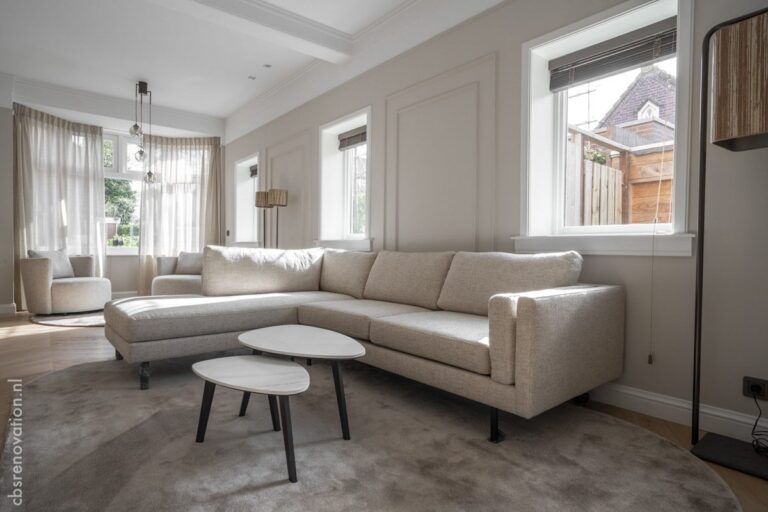 Living room with a corner sofa, panelled walls and round coffee tables