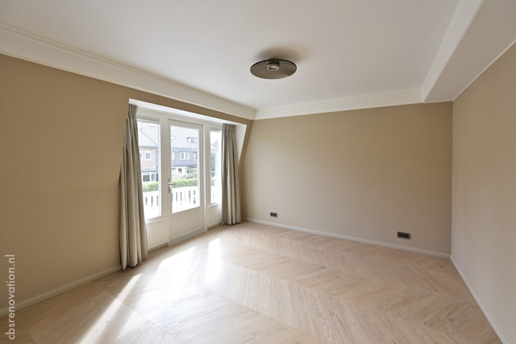Bedroom with French doors onto the balcony and a herringbone floor