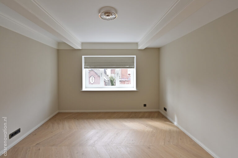 Bedroom with a fabric blind at the window and a herringbone floor
