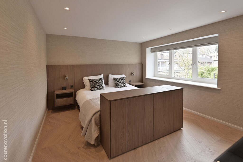 Bedroom with a fitted wooden headboard wall and built-in bedside units