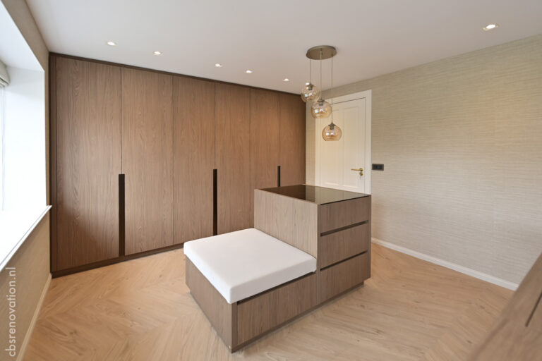 Bedroom with a full-height fitted wardrobe wall and an upholstered bench