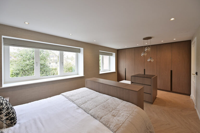 Bedroom with a wide window and fitted wardrobes