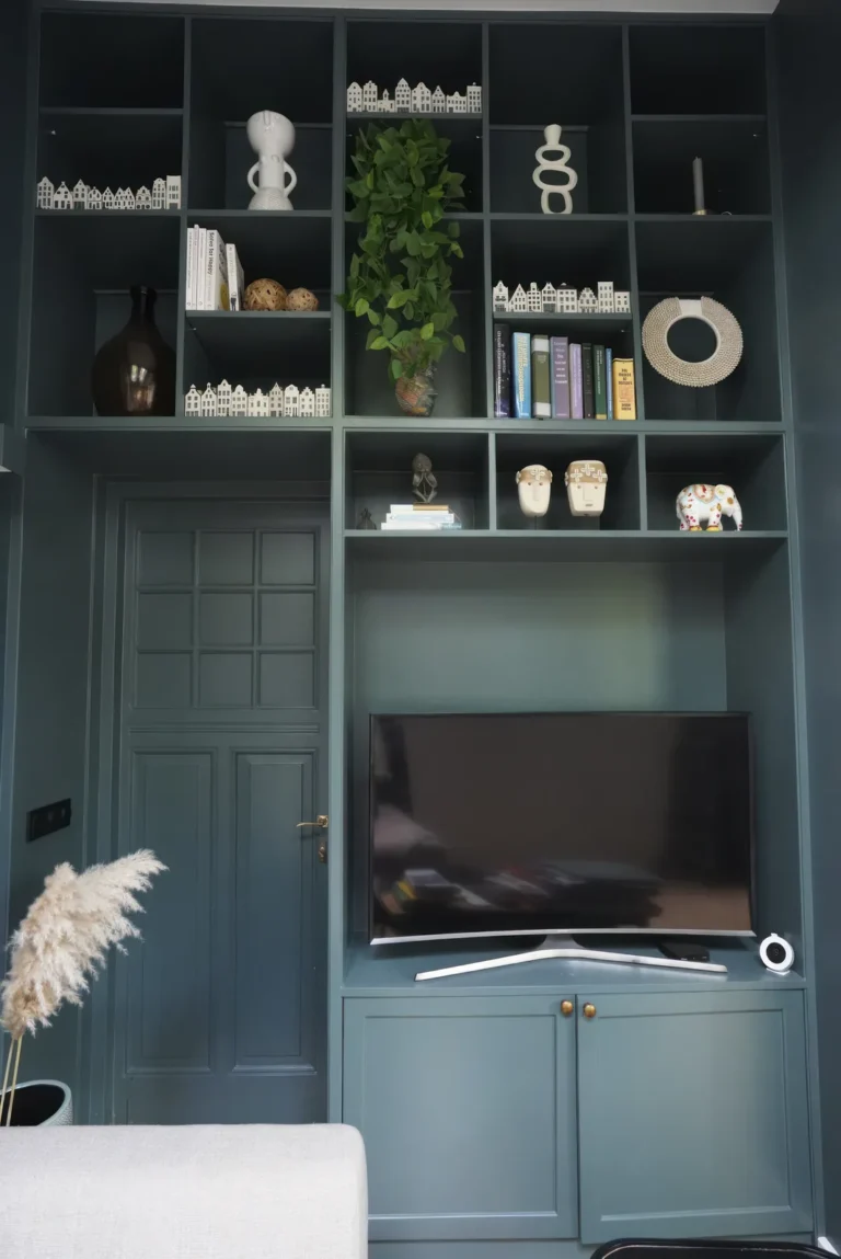 Built-in dark green shelving unit with open display niches