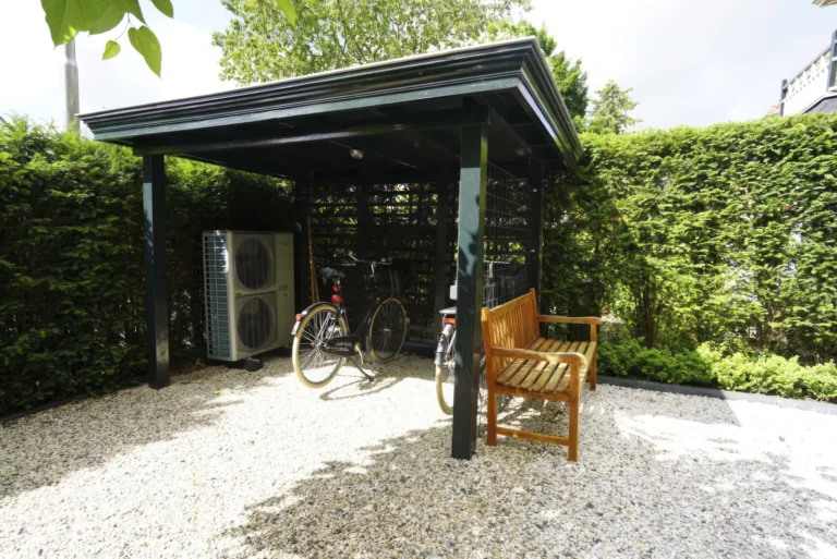 Garden carport in black timber with the heat pump units and bicycle storage